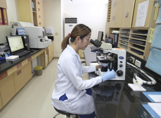 female doctor looking through a microscope