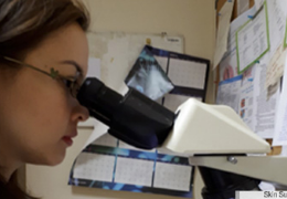 medical personnel looking through a microscope