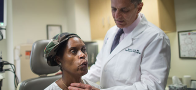 male doctor examining a female patients throat