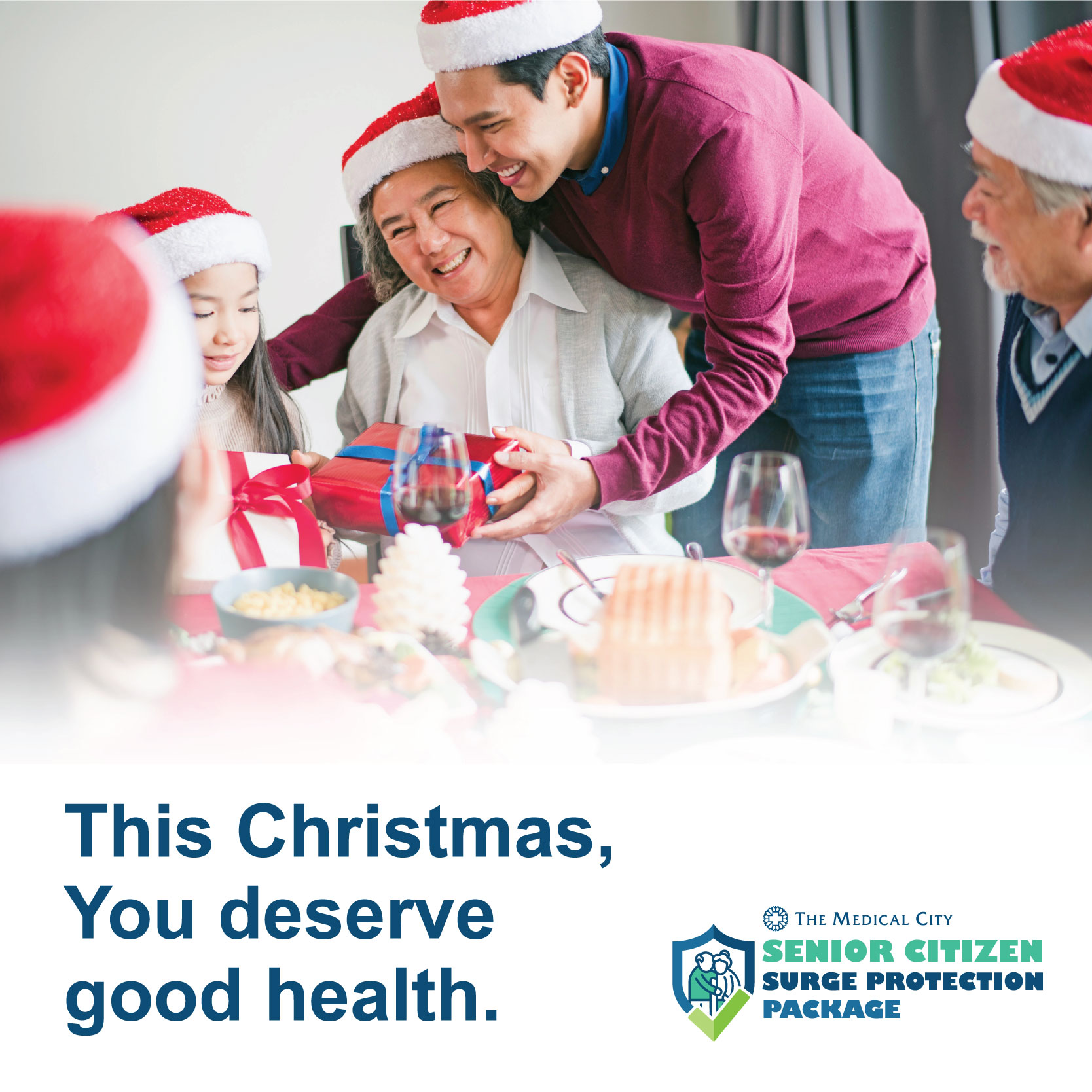 man wearing a santa hat with his family hugging his grandma