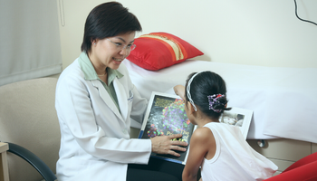 female doctor reading with a young female patient
