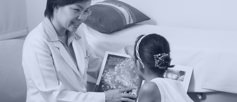 female doctor reading a book to a child