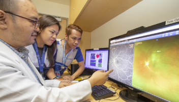 a doctor and two nurses looking at a scan result